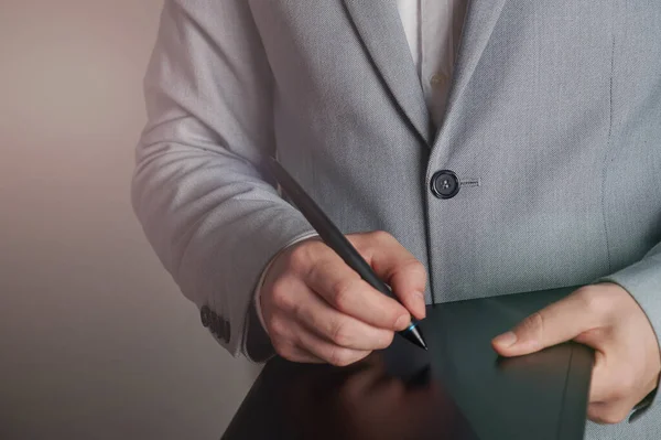 Man in suit signing digital contract close up view