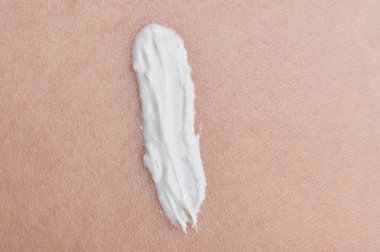 Temiz bebek yüzü üzerinde beyaz cilt kremi çizgisi