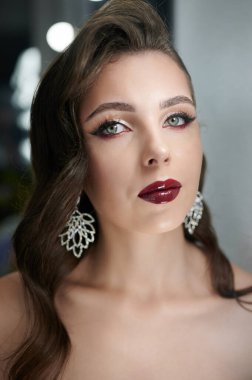 Şık esmer kadın, bulanık stüdyo arka planında yakın plan portresi.