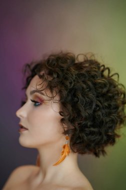 Yeşil ve mor arka planda genç bir kadının profil portresi