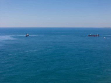 Kargo gemisi mavi deniz arka planında hava aracı görüntüsünde.