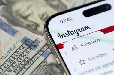 New York, ABD - 12 Eylül 2025: Akıllı telefon ekranında Instagram takipçileri menüsü ve dolar yakın plan görüntüsü 