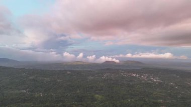 Bereketli tepelerin ve dingin manzaradaki yumuşak günbatımı bulutlarının nefes kesici hava manzarası..