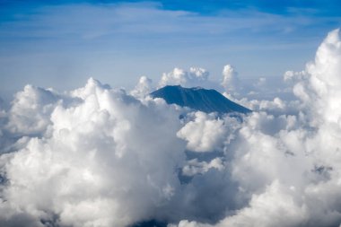 Airplane flying above Mount Agung volcano, Bali, Indonesia clipart