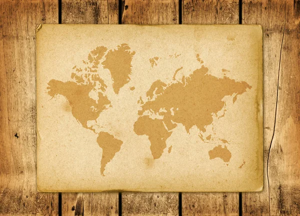 Винтажный пергамент карты мира на деревянной стене — стоковое фото