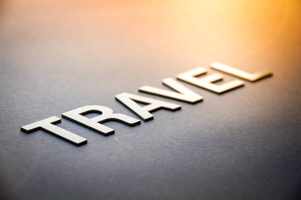 Word travel written with white solid letters on a board
