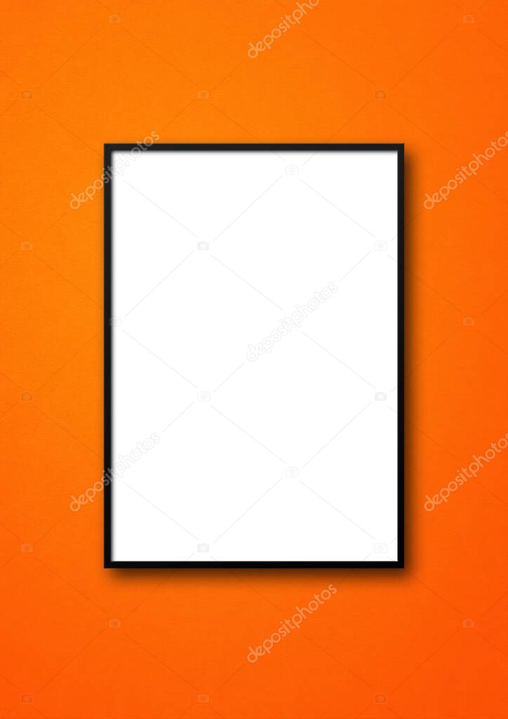 Black picture frame hanging on an orange wall. Blank mockup template