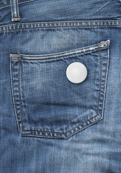 蓝色斜纹棉布口袋背景上的空白徽章 — 图库照片