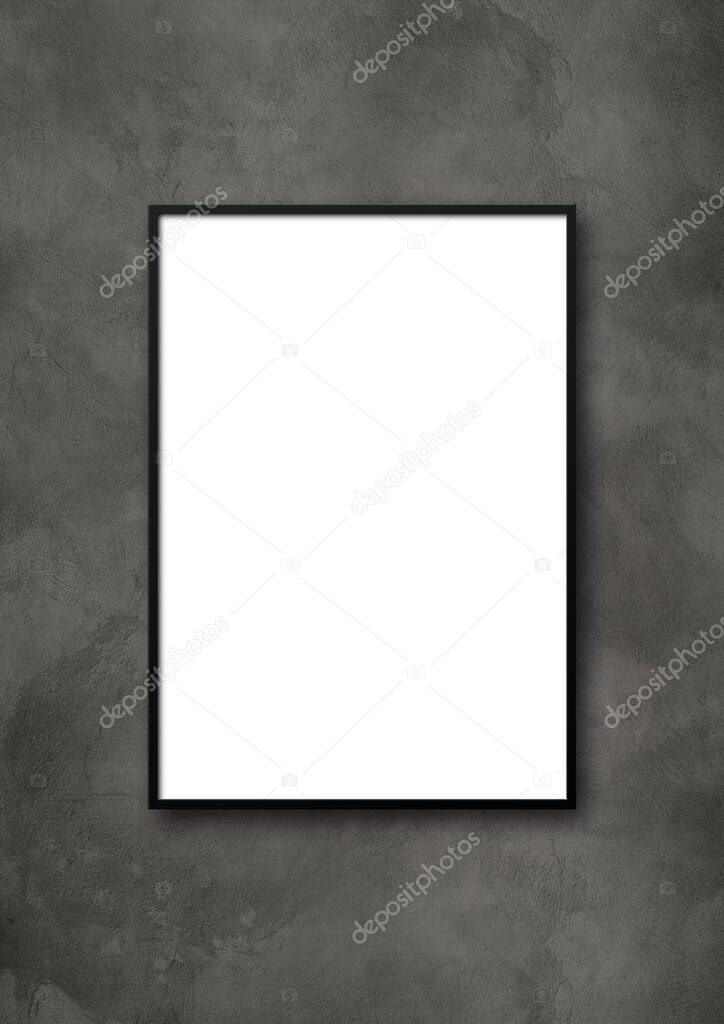 Black picture frame hanging on a dark concrete wall. Blank mockup template