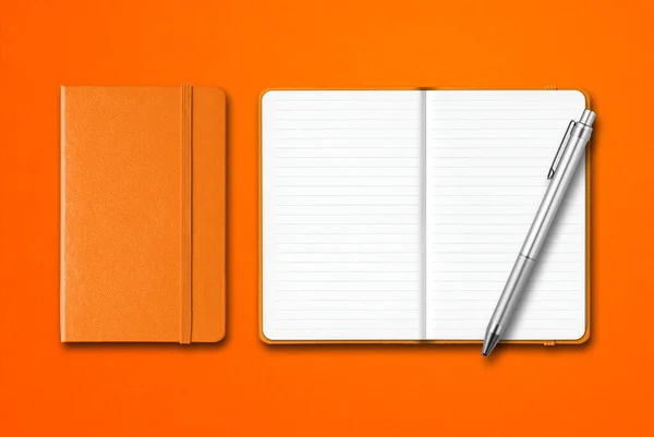 オレンジ色の背景にペンで囲まれた閉じた開いたラインノートブック — ストック写真