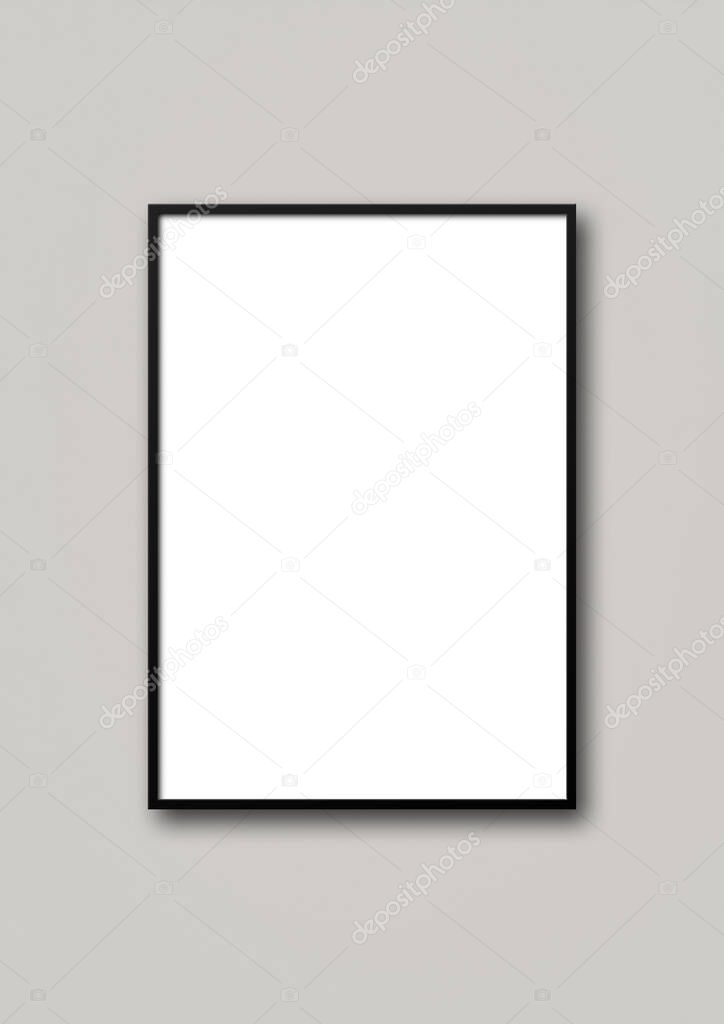 Black picture frame hanging on a light grey wall. Blank mockup template
