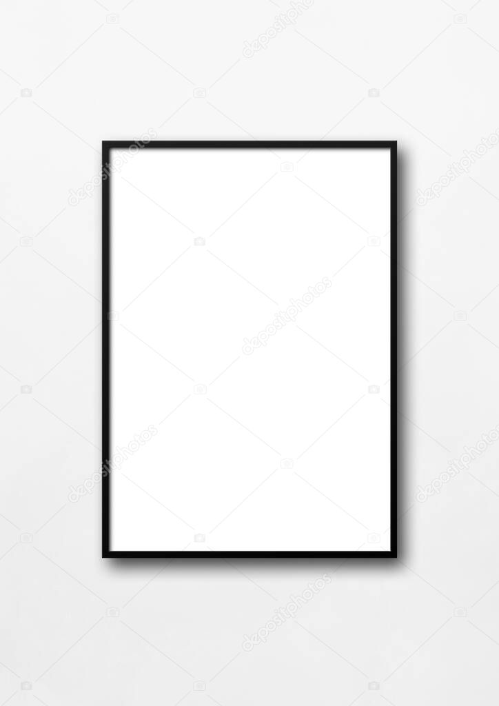 Black picture frame hanging on a white wall. Blank mockup template