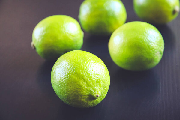 Group of fresh organic limes on a black table background