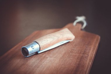 Siyah mutfak masasında tahta kesme tahtası ve çakı.