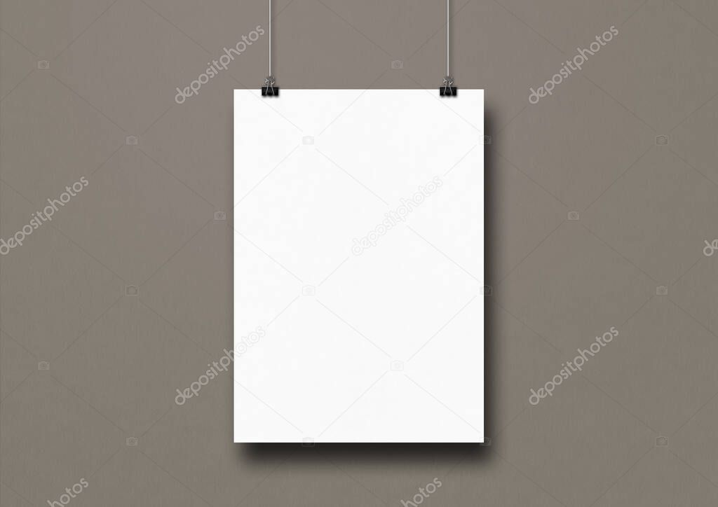 White poster hanging on a grey wall with clips. Blank mockup template