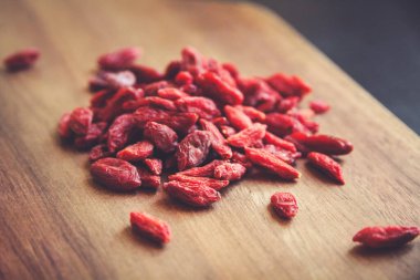Tahta kesme tahtasındaki Goji üzümleri.