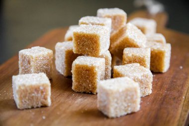 Tahta kesme tahtasının üzerinde kahverengi kamış şeker küpleri