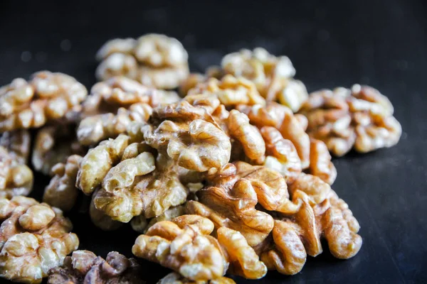 Siyah ahşap bir masada ceviz çekirdekleri. Yakın görünüm