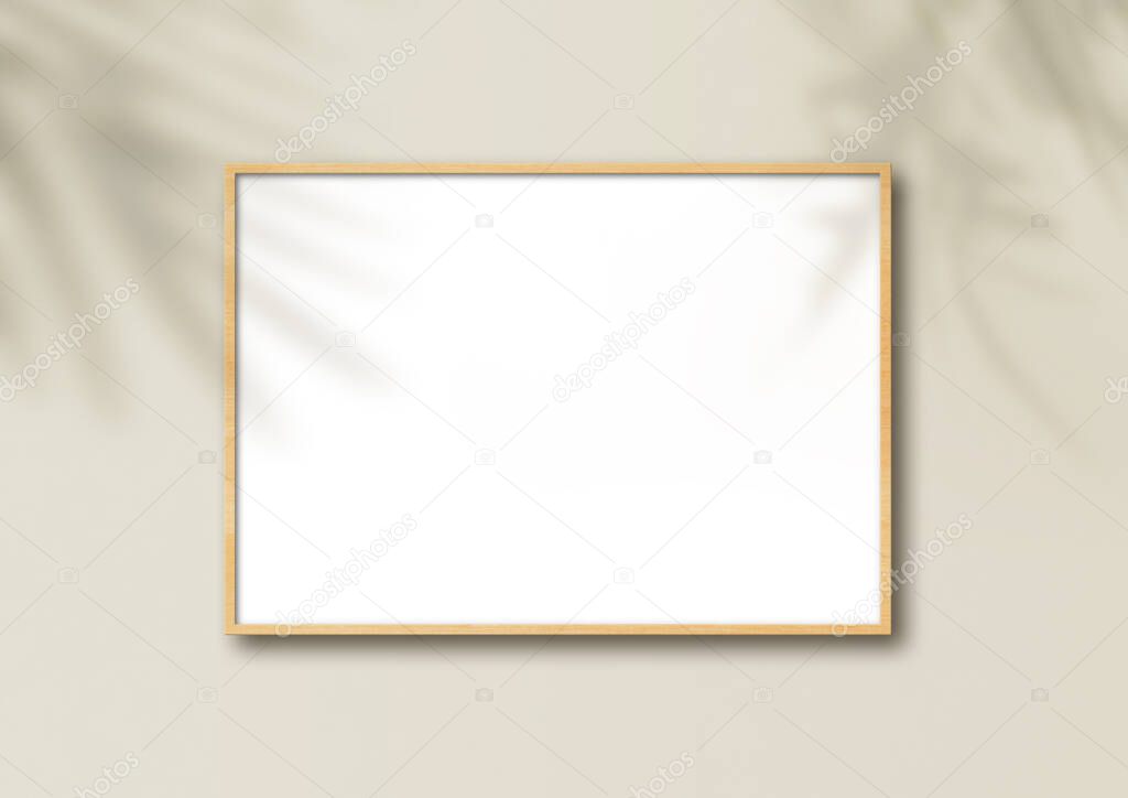 Horizontal wooden picture frame hanging on a light beige wall. Floral shadows. Blank mockup template