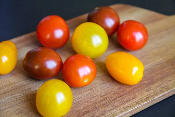 Tomates Coquetel Coloridos Uma Placa Corte Madeira — Fotografia de Stock