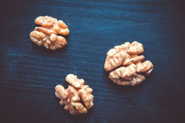 Siyah ahşap bir masada ceviz çekirdekleri. Yakın görünüm