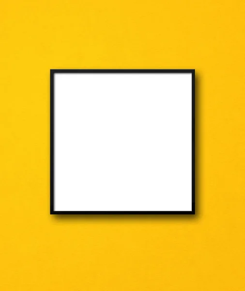 挂在黄墙上的黑色正方形相框 空白模型模板 — 图库照片