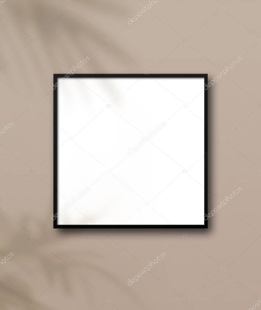 Black square picture frame hanging on a light beige wall. Floral shadows. Blank mockup template