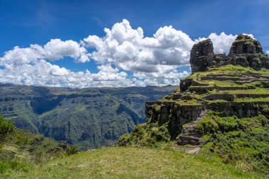 Peru 'daki Waqrapukara arkeolojik sahasında engebeli bir dağ zirvesinde, Andean manzarasının çarpıcı manzaralarını sunan teraslı taş kalıntıları yer almaktadır.