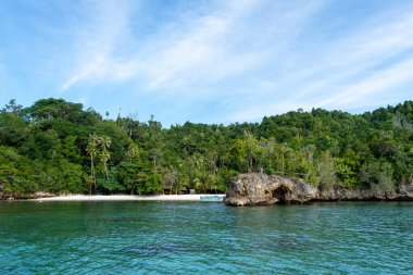Sulawesi, Endonezya 'daki güzel Togian takımadasının bir parçası olan Waleakodi Adası' ndaki Lia plajının beyaz kumlarında renkli bir pirogue bulunur.