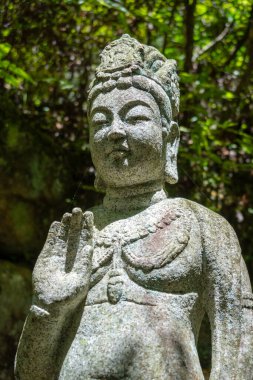 Hiroşima 'daki Mitaki-Dera tapınağındaki yemyeşil çimenlikte oturan Amida Buddha' nın heykeli huzur ve ruhsal huzur yayıyor.