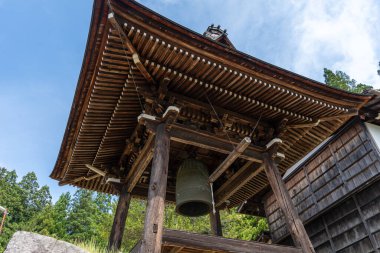 Japonya 'nın Takayama kentindeki Soyuji Tapınağı' ndaki büyük bronz çan, karmaşık kirişleri ve eğimli çatısı olan geleneksel bir ahşap kulede bulunmaktadır.