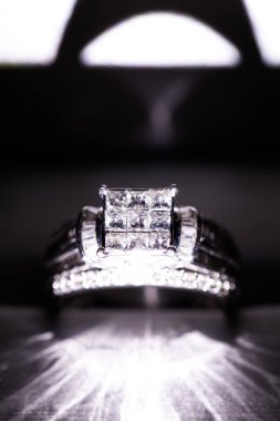 Glint/yansıması ile bir kutu içinde bir elmas nişan yüzüğü. Prenses kesilmiş elmas parıltılı.