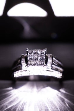 Glint/yansıması ile bir kutu içinde bir elmas nişan yüzüğü. Prenses kesilmiş elmas parıltılı.