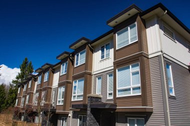 Modern alçak ahşap çerçeve karmaşık. Yeni apartman güneşli ilkbaharda çiçek açan ağaçlar ile.