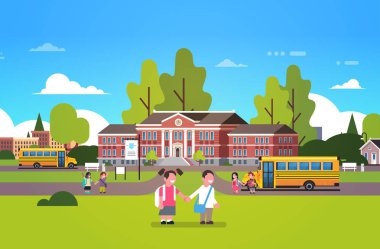 Çift öğrenciler eller okul bahçesinde sarı otobüs çocuk Binası küçük ilkokul öğrencileri manzara arka plan düz tutun