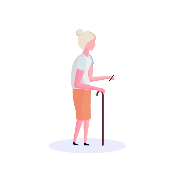 Vieille femme bâton de marche en utilisant smartphone personne âgée grand-mère marcher isolé personnage de bande dessinée pleine longueur plat — Image vectorielle