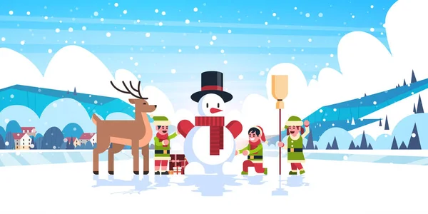 Green Elves Group Making Snowman Merry Christmas Happy New Year — стоковый вектор