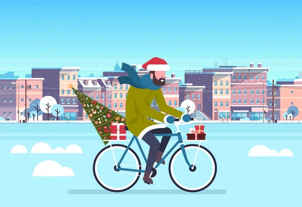 Man rider bike med fir tree presentbox över staden gatan byggnader stadsbilden bakgrund merry christmas nyår begreppet platt horisontellt — Stock vektor