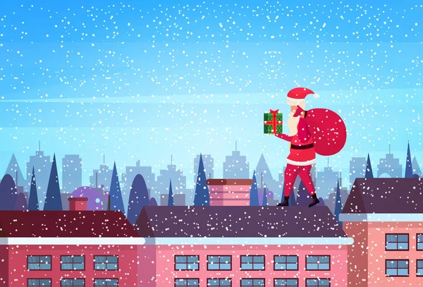 サンタ ホールド ギフト ボックス スタンド屋根のビルに住宅冬街路景観背景メリー クリスマス新年あけましておめでとうございますコンセプト フラット横 — ストックベクタ