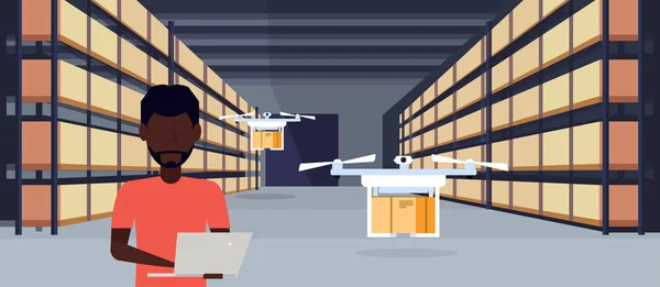 Afro homem operador drone voando trabalhando armazém interior usando laptop pacote caixa em rack entrega logística serviço de carga conceito masculino personagem retrato horizontal plana —  Vetores de Stock