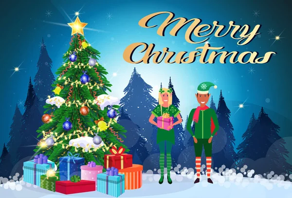Mix kostým elf pár závod drží dárkové krabice stojící poblíž fir tree šťastný nový rok Veselé Vánoce koncept rovinnou a vodorovnou nápis — Stockový vektor