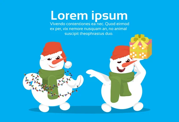 Heureux bonhommes de neige porter chapeau rouge tenir lumières enveloppé boîte cadeau cadeau joyeux noël heureux nouvelle année vacances concept plat horizontal copie espace — Image vectorielle