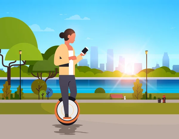 Vrouw rit elektrische mono wiel met behulp van smartphone meisje moderne persoonlijke vervoer buiten natuur stad stadspark stadsgezicht zonsondergang achtergrond horizontale flat — Stockvector