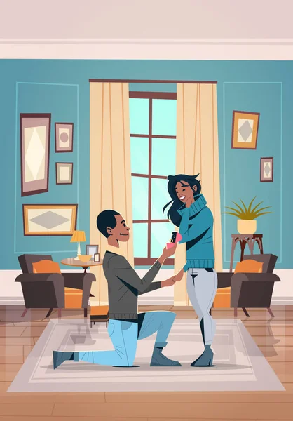 Diz çökmüş adam nişan yüzüğü kadın evlenme teklif tutarak onu mutlu sevgililer günü kavramı Afro-Amerikan çift aşk evlilik teklif oturma odası iç dikey evlenmek — Stok Vektör