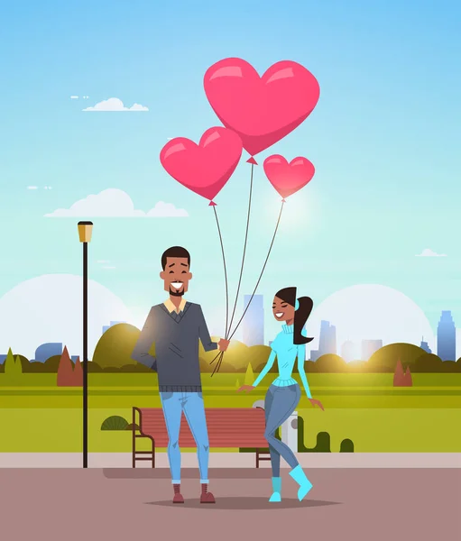 男与える女ピンクのハート形空気風船幸せなバレンタインデー概念アフリカ系アメリカ人カップル市都市公園都市景観上恋背景垂直フラット — ストックベクタ