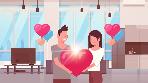 Pareja sosteniendo rosa corazón forma feliz día de San Valentín concepto hombre mujer amantes de pie juntos moderno apartamento hogar colorido aire globos plana horizontal — Vector de stock