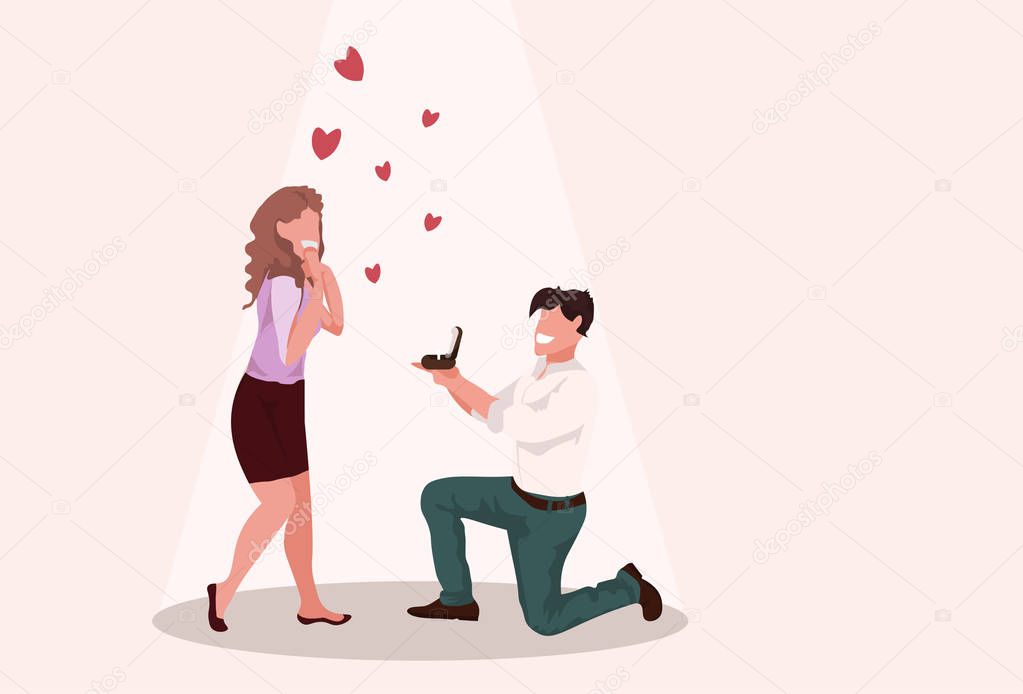 man kneeling holding engagement ring proposing to surprised woman marry him happy valentines day concept couple in love marriage offer full length horizontal