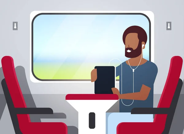 man train passenger listening audio book with headphones african american guy sitting red armchair railway traveling concept male character portrait horizontal