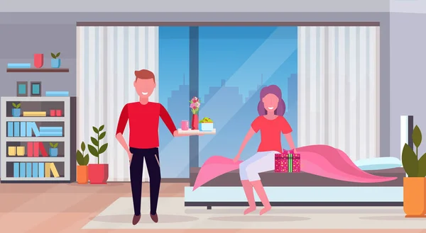 Hombre trayendo desayuno para su mujer en la cama feliz 8 marzo mujer día concepto marido haciendo sorpresa a la esposa dormitorio moderno interior longitud completa plana horizontal — Vector de stock