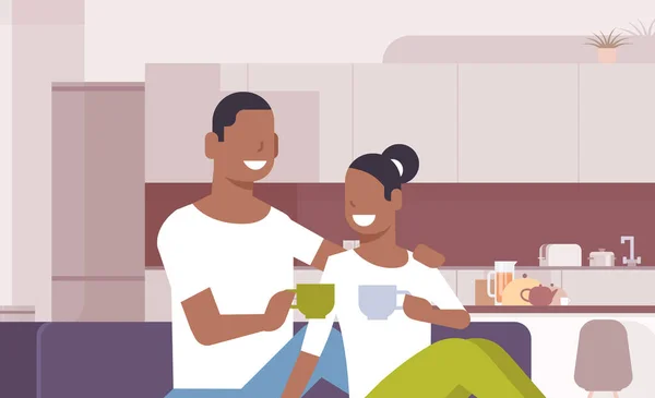 Pareja beber té café africano americano hombre mujer sentado en sofá feliz amantes comunicar moderno cocina interior masculino femenino dibujos animados personajes retrato horizontal — Archivo Imágenes Vectoriales